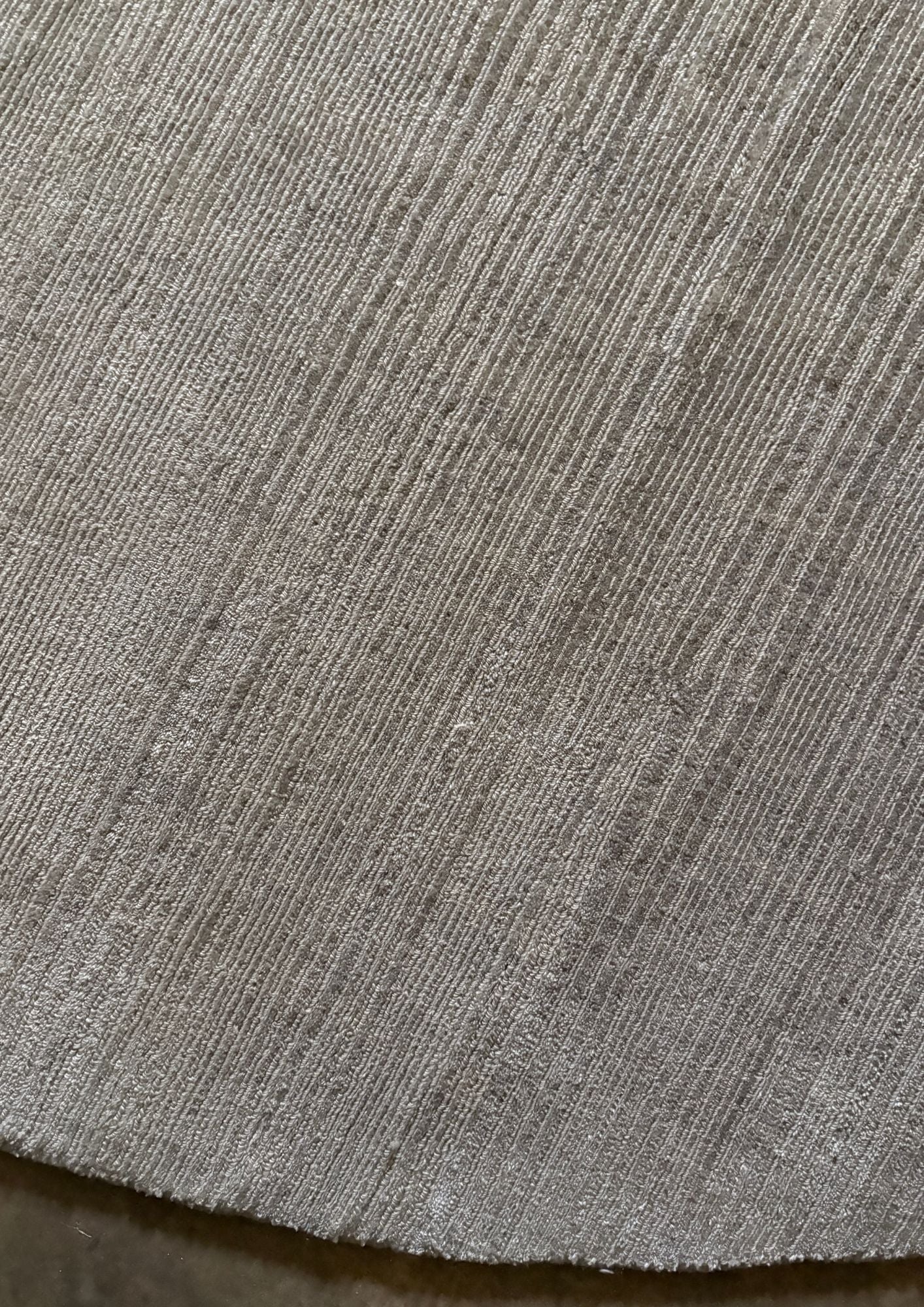 Close-up of a textured handmade luxury gray rug
